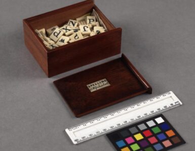 A historic spelling alphabet box filled with letter tiles.