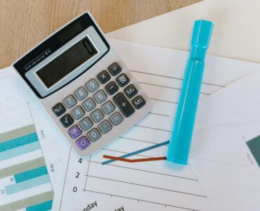 A calculator and marker on printed data charts for a statistics lesson.