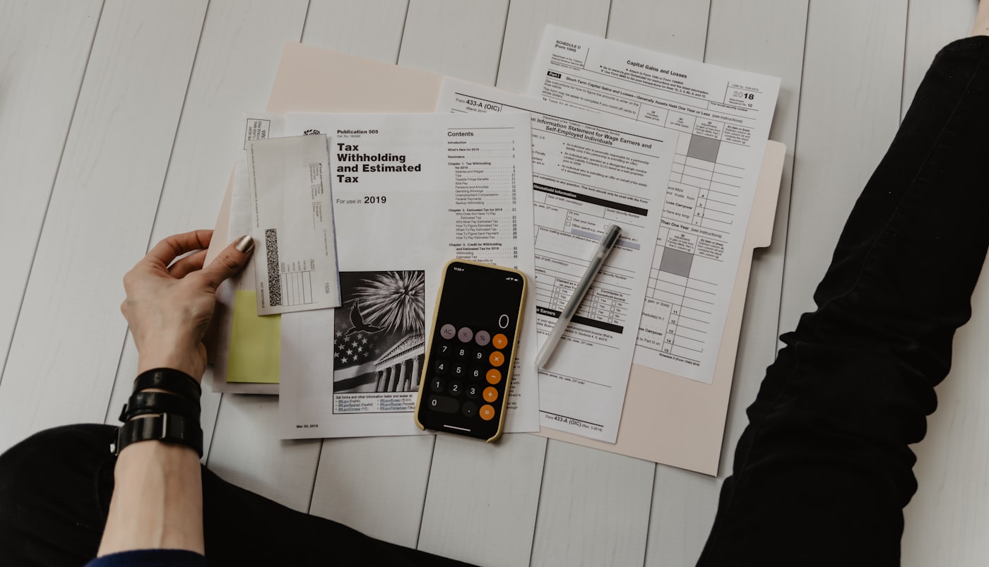 A calculator and financial paperwork used to compare college costs and aid estimates