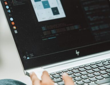 Student working on a laptop with code on the screen
