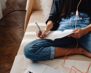 A student organizing notes beside a laptop to reduce mental load while studying