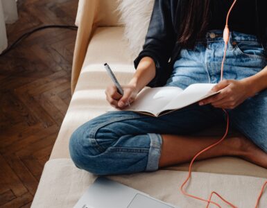 A student organizing notes beside a laptop to reduce mental load while studying