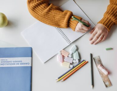 A student writes handwritten notes in a notebook while studying.