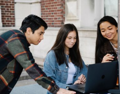 Students reviewing college options together on a laptop