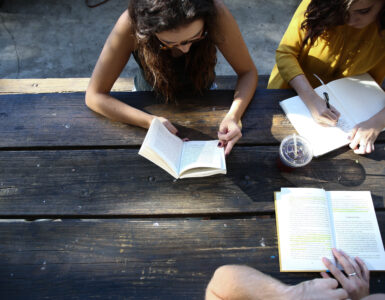 Students reading and writing notes together at a table