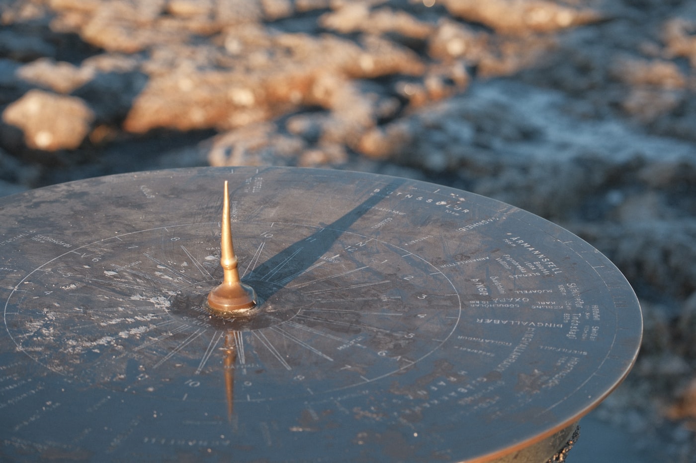 A sundial casting a sharp shadow in warm sunlight
