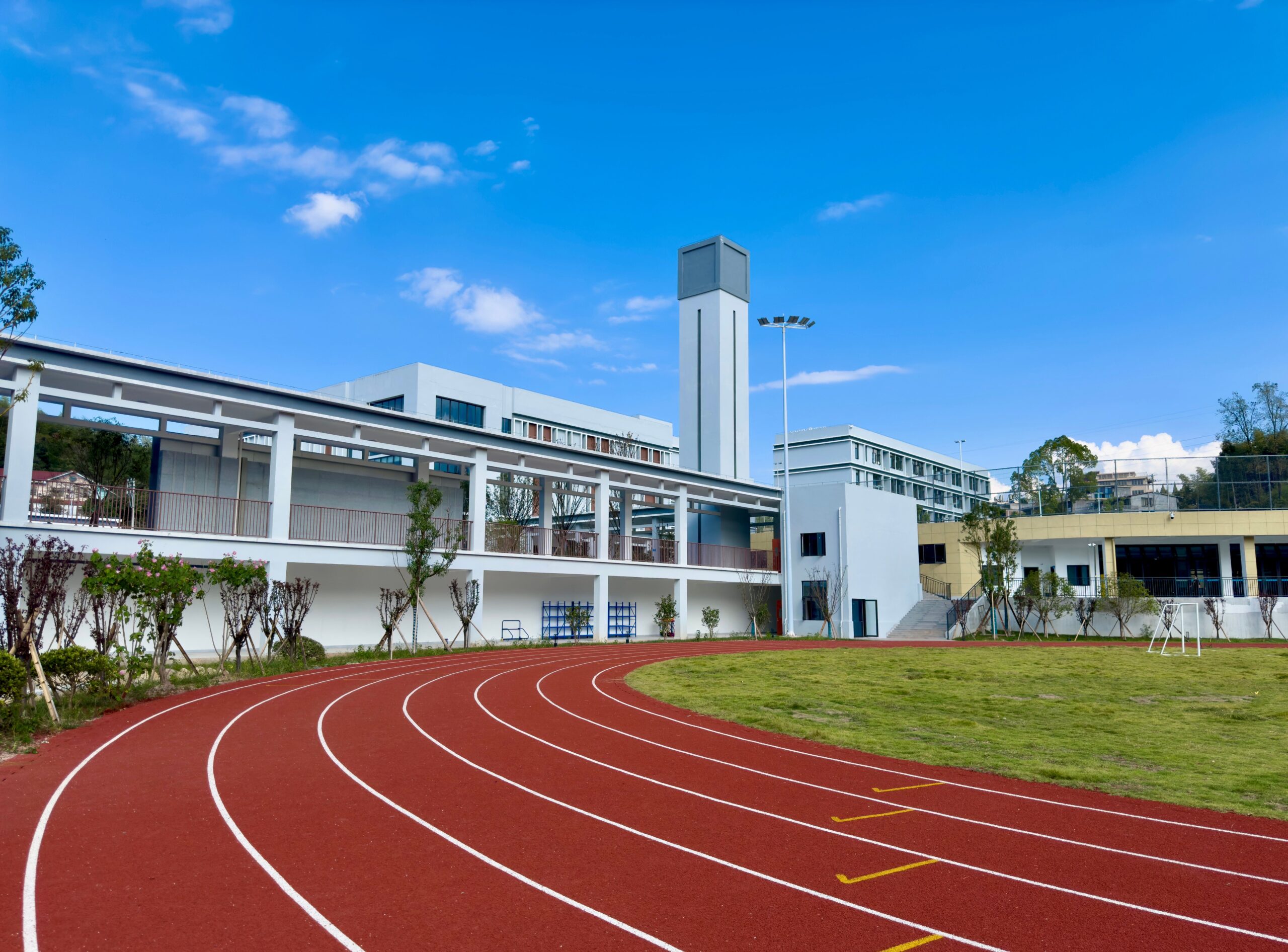 A sunny outdoor track field where heat exposure can build during practices and events.