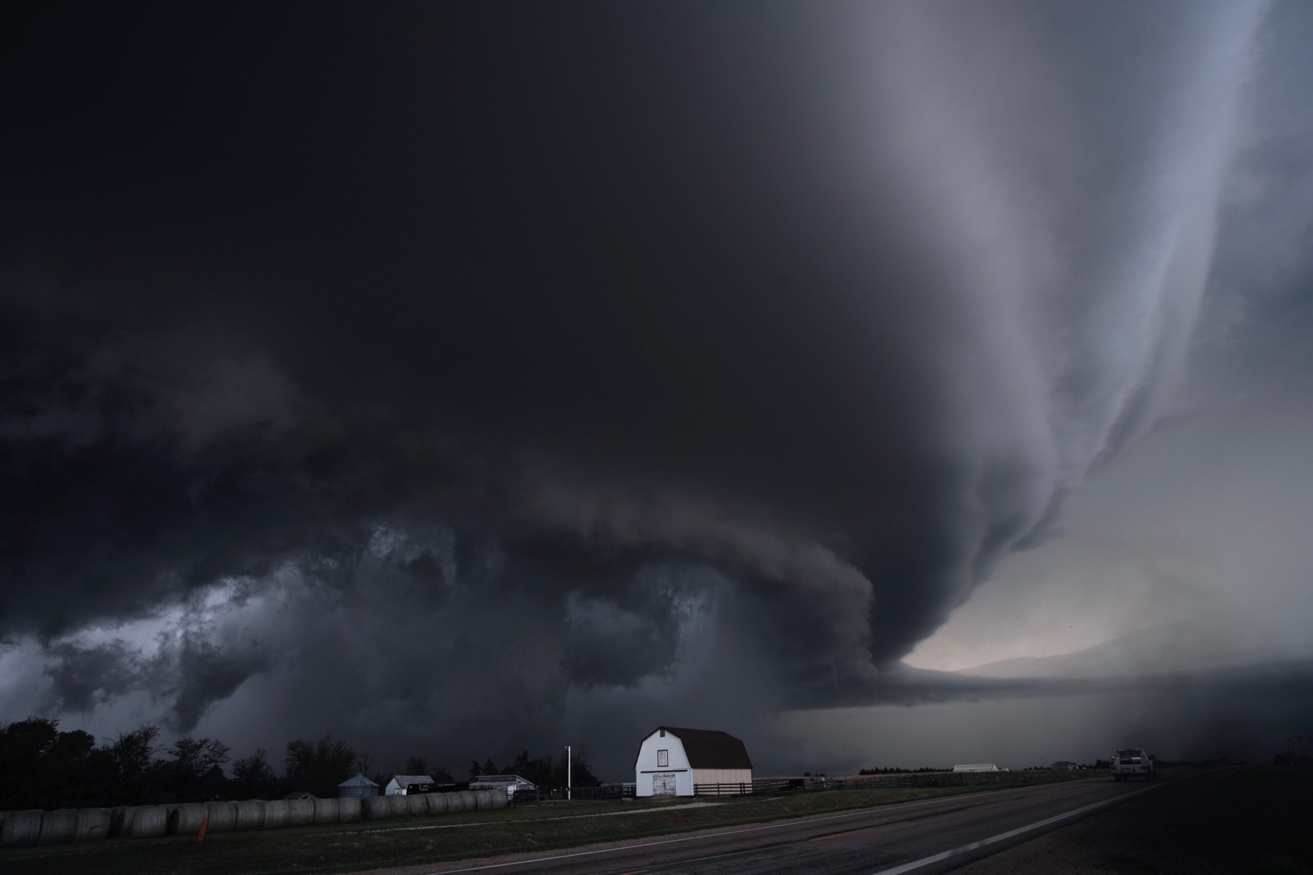 A large supercell thunderstorm cloud rising over open land in Kansas