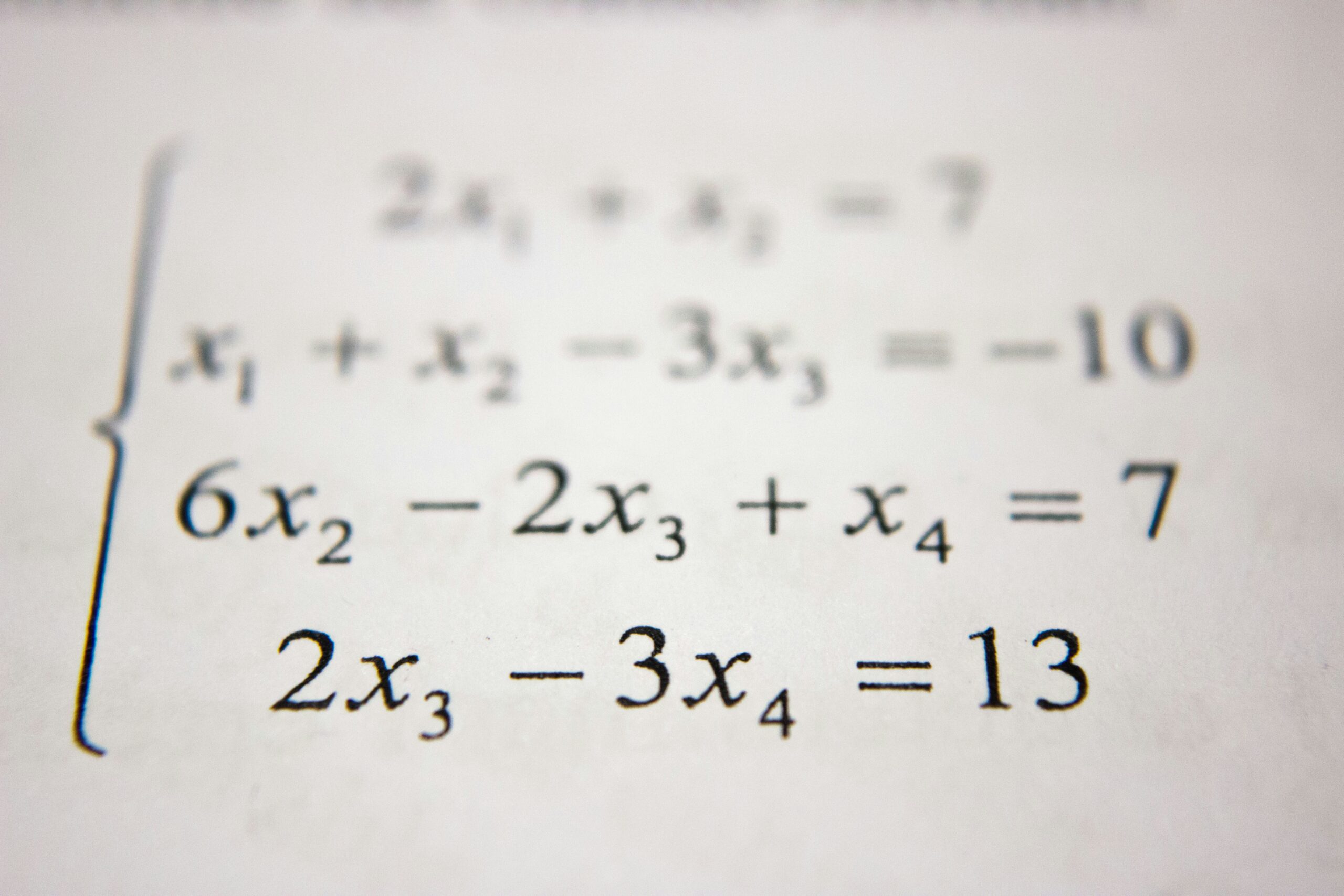 A close-up of algebra equations printed on paper