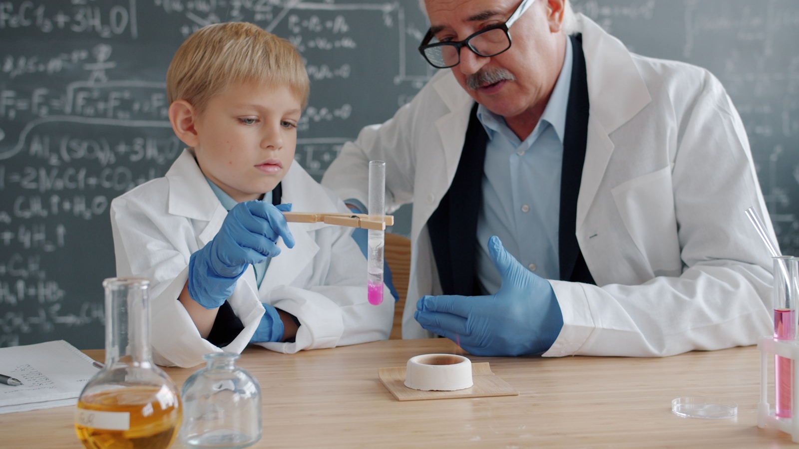 A teacher and student observe a science experiment in a classroom lab.