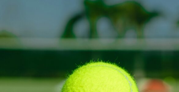 A tennis ball resting on a grass court near the net