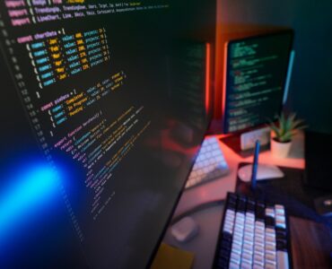 Programming code on computer screens representing how Unicode helps devices handle text consistently