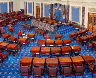 The United States Senate chamber with rows of desks arranged around the presiding officer's desk.