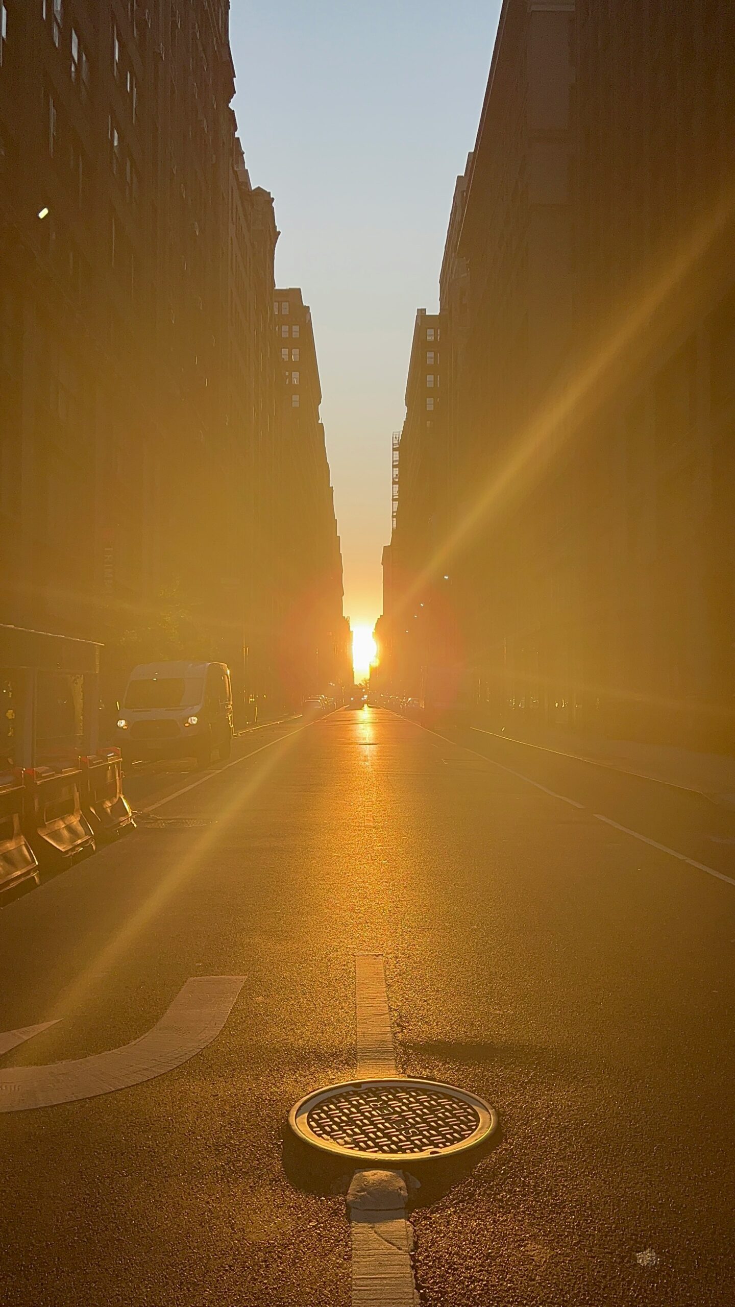 A sunlit city street where pavement absorbs and stores heat on a hot day.