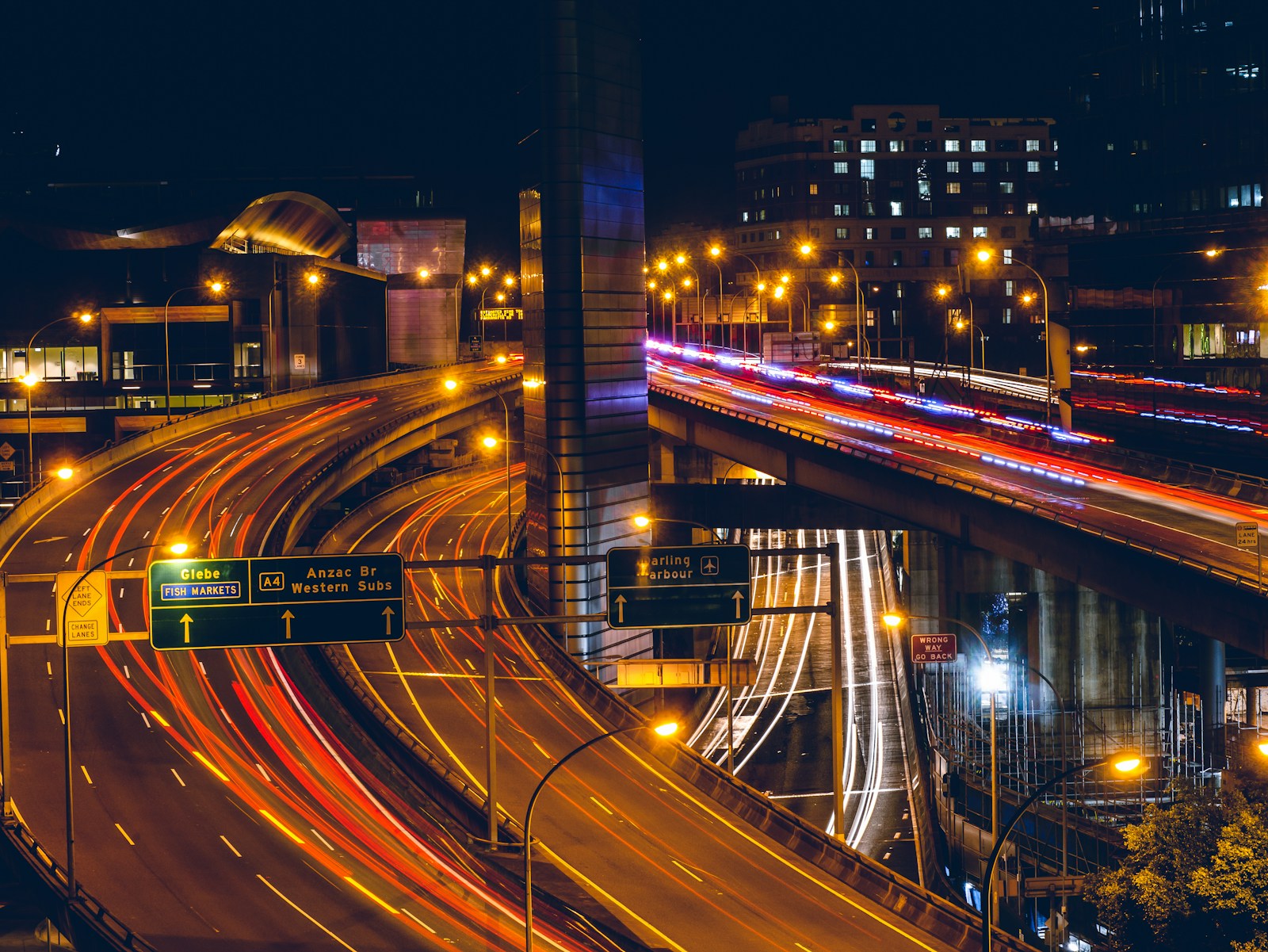 Streams of vehicle lights moving across an urban overpass at night
