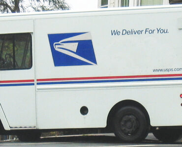 A USPS delivery truck on a residential street, representing how ZIP Codes connect addresses to delivery routes