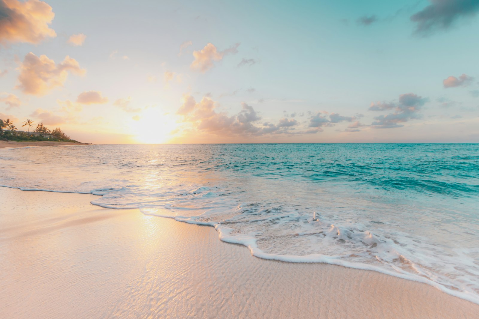 Bright sunlight over a sandy beach and blue ocean water, where UV exposure can be strong