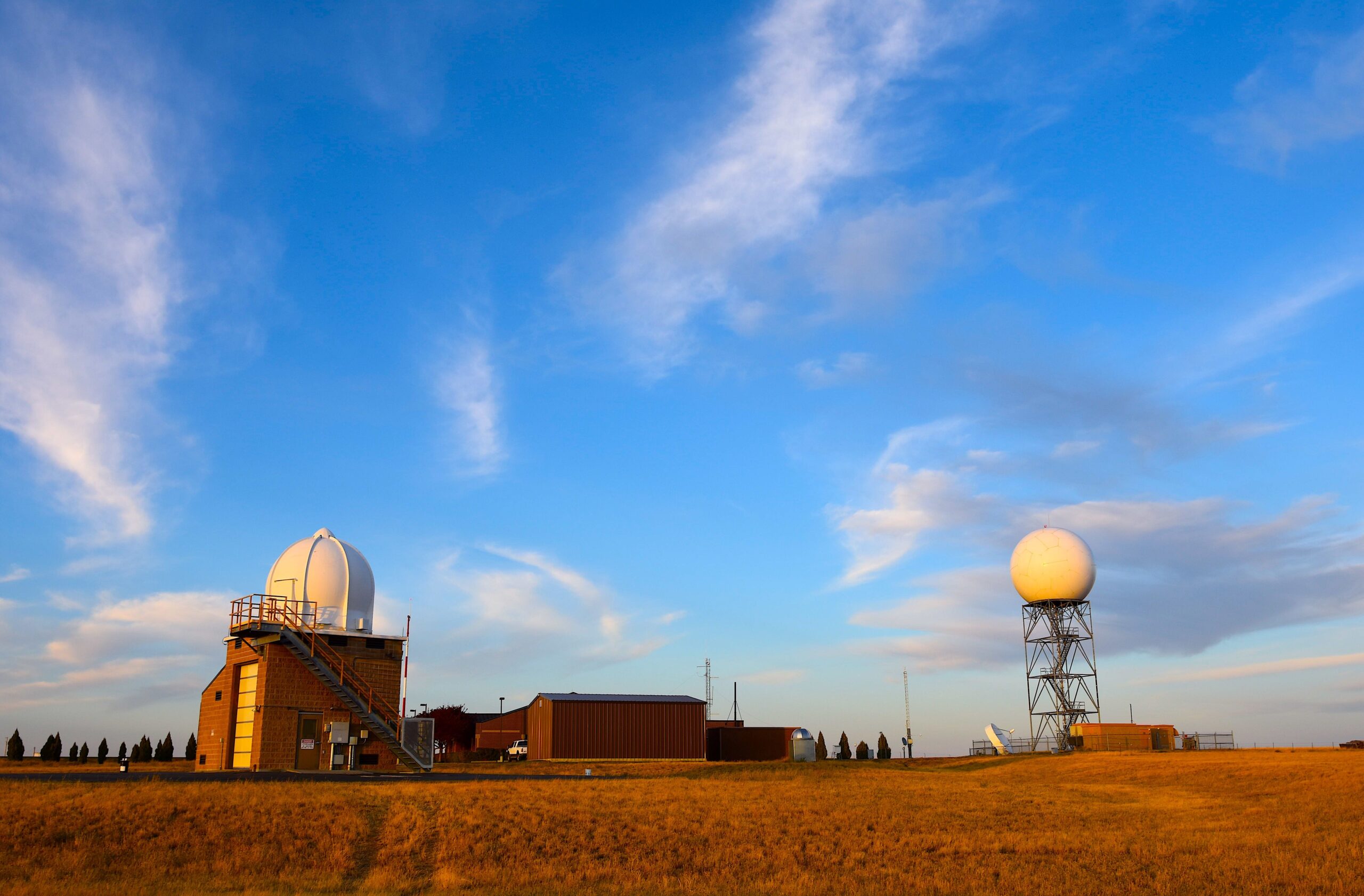 A weather radar station in an open field, representing storm monitoring and official forecasts.