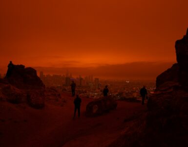 A city skyline under orange wildfire smoke haze