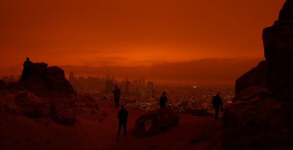 A city skyline under orange wildfire smoke haze