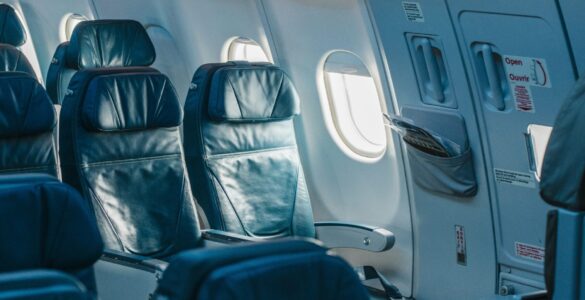 Rows of passenger seats inside a pressurized airplane cabin during flight.
