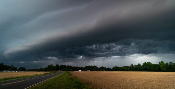 Dark storm clouds over a rural road as moisture-rich air brings heavy precipitation inland.