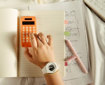 A student using a calculator beside math notes while working through probability updates.