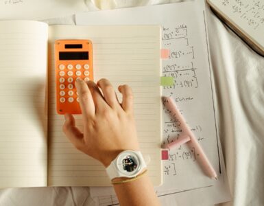 A student using a calculator beside math notes while working through probability updates.