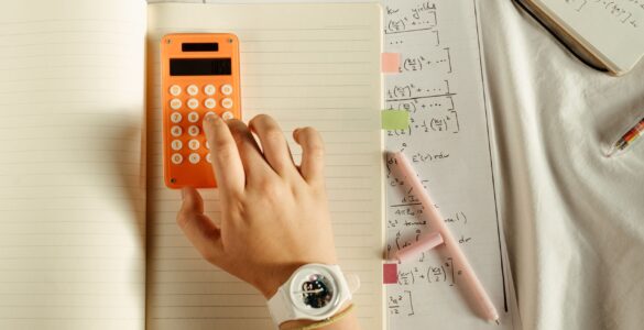 A student using a calculator beside math notes while working through probability updates.