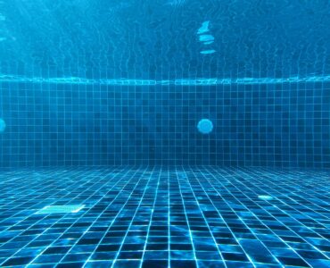 Blue swimming pool water with ripples showing how light and depth affect water color.