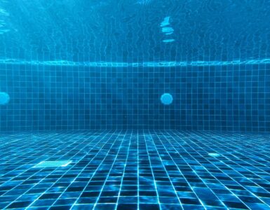 Blue swimming pool water with ripples showing how light and depth affect water color.