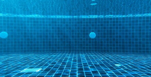 Blue swimming pool water with ripples showing how light and depth affect water color.