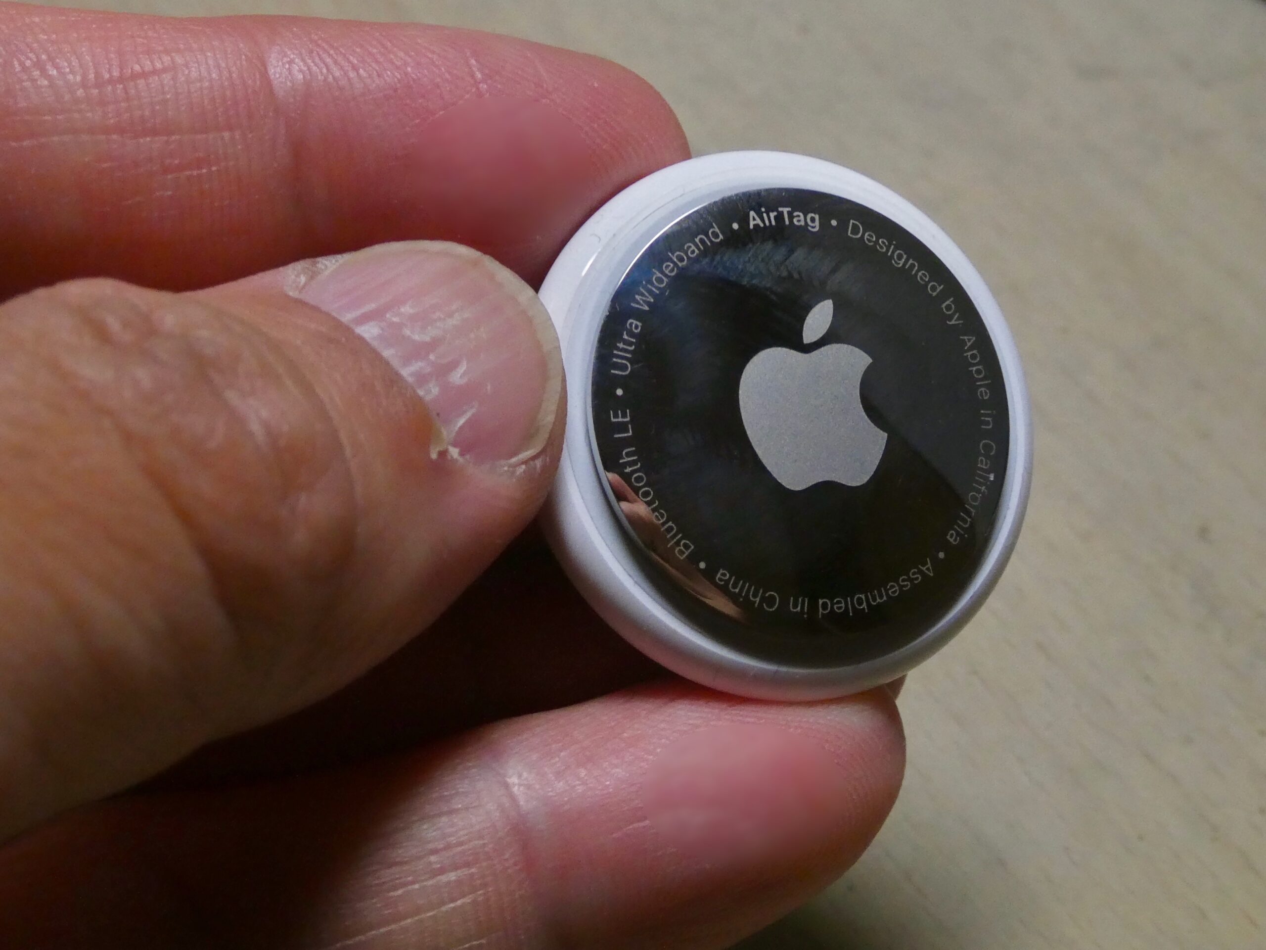 A close-up of a small Bluetooth tracking tag that can broadcast signals to nearby phones.
