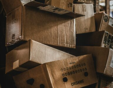 Stacks of cardboard boxes in a warehouse, representing how inventory decisions can grow as demand signals move through a supply chain.