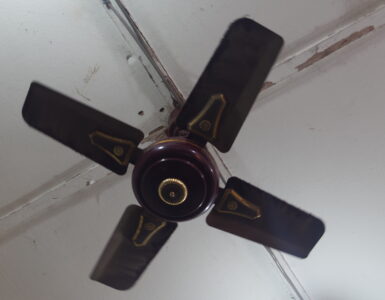 A four-blade ceiling fan mounted above an indoor room