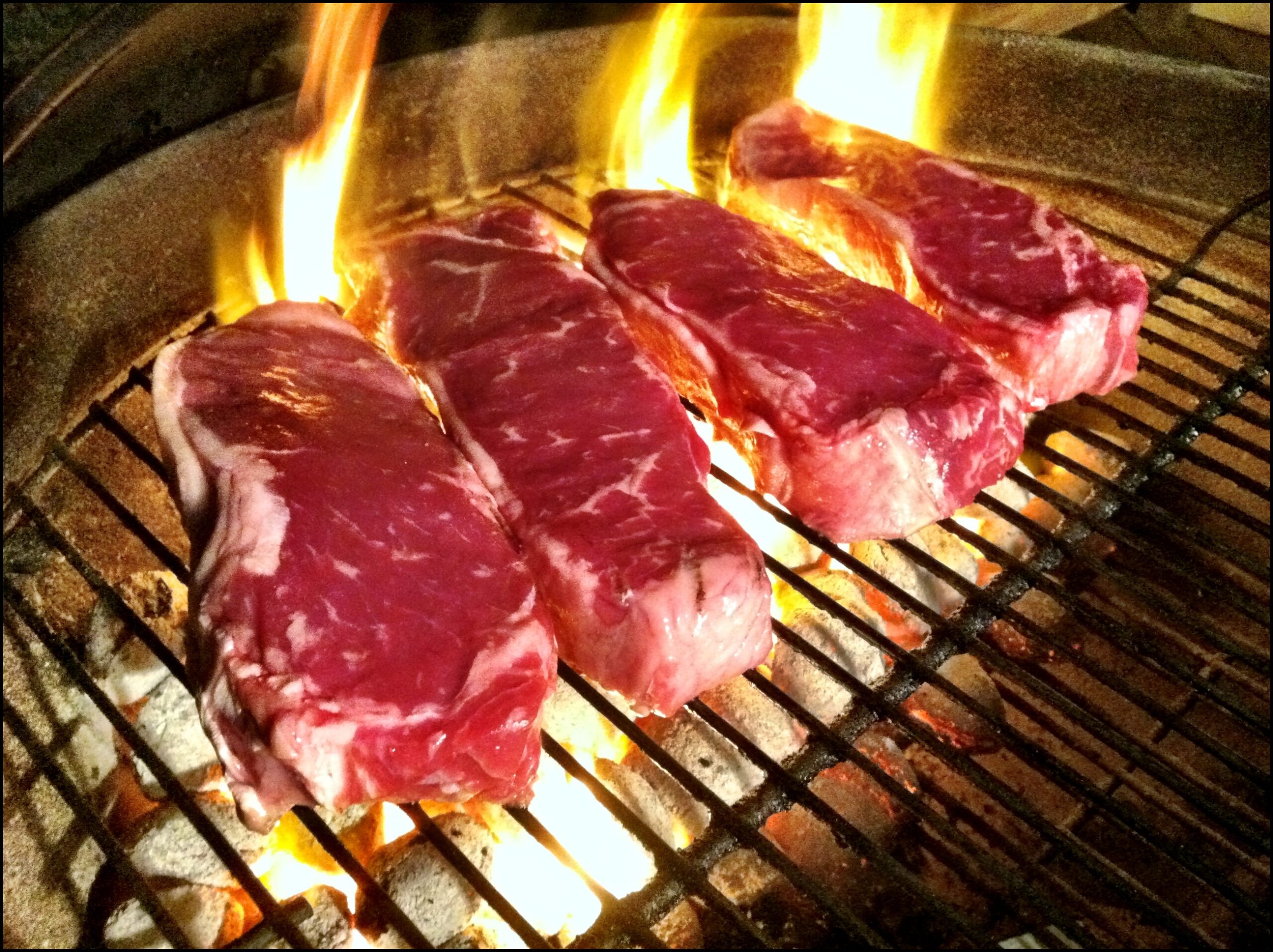 Food cooking over a hot grill, where glowing coals transfer heat by radiation and rising air.