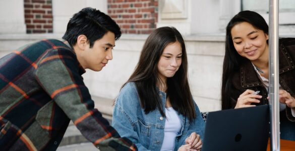 Students using a laptop to compare college options and academic fit.