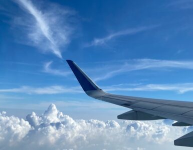 An airplane wing above clouds, representing aircraft-based cloud seeding operations in suitable weather conditions.