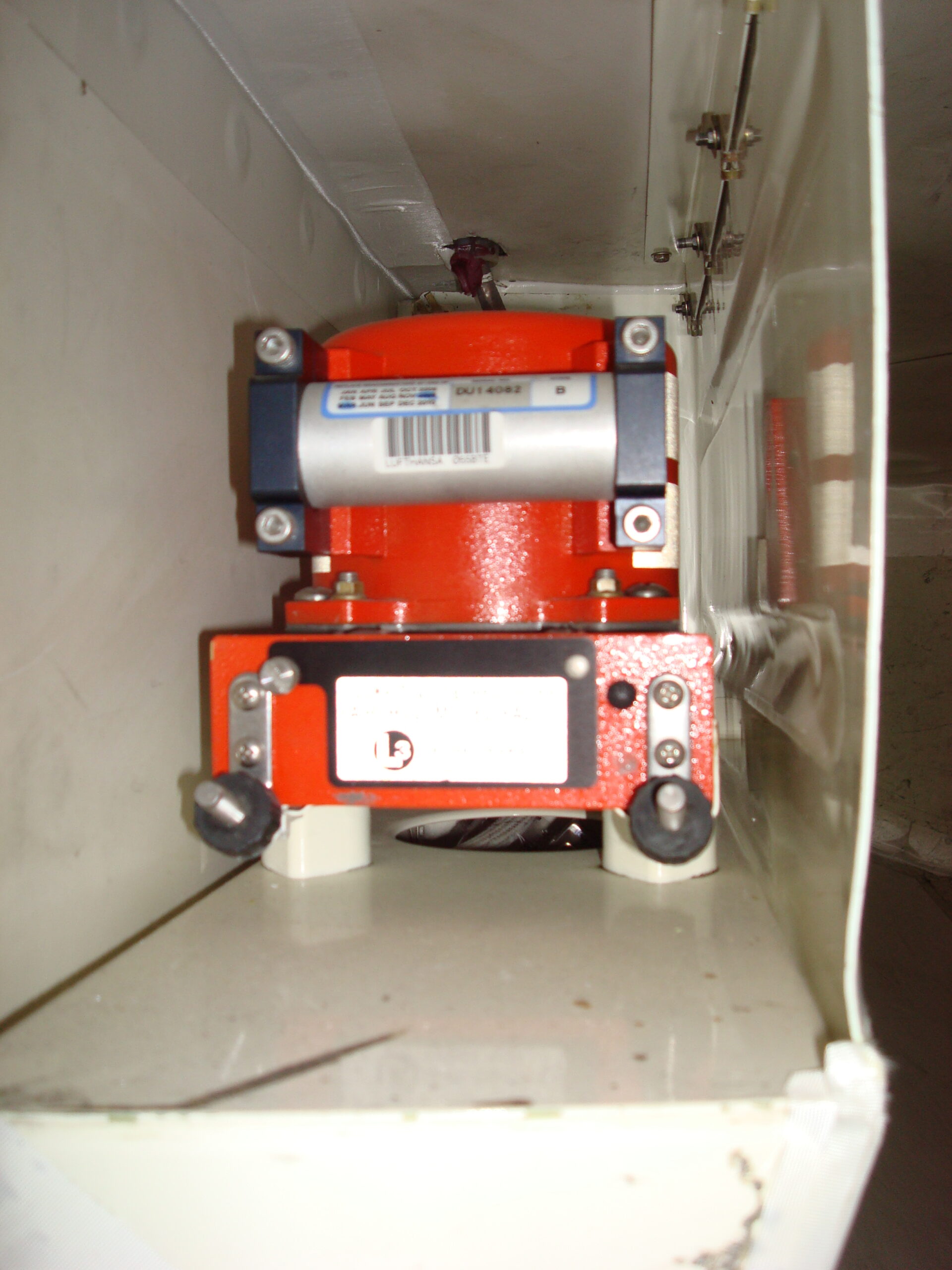 A bright orange cockpit voice recorder mounted inside an aircraft equipment bay.