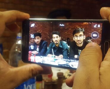 A smartphone camera being used in low light, where software can combine several frames into one clearer photo.