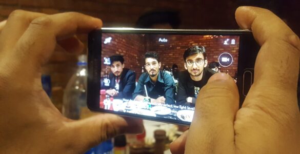 A smartphone camera being used to capture a digital photo that may be saved as HEIC or JPEG.