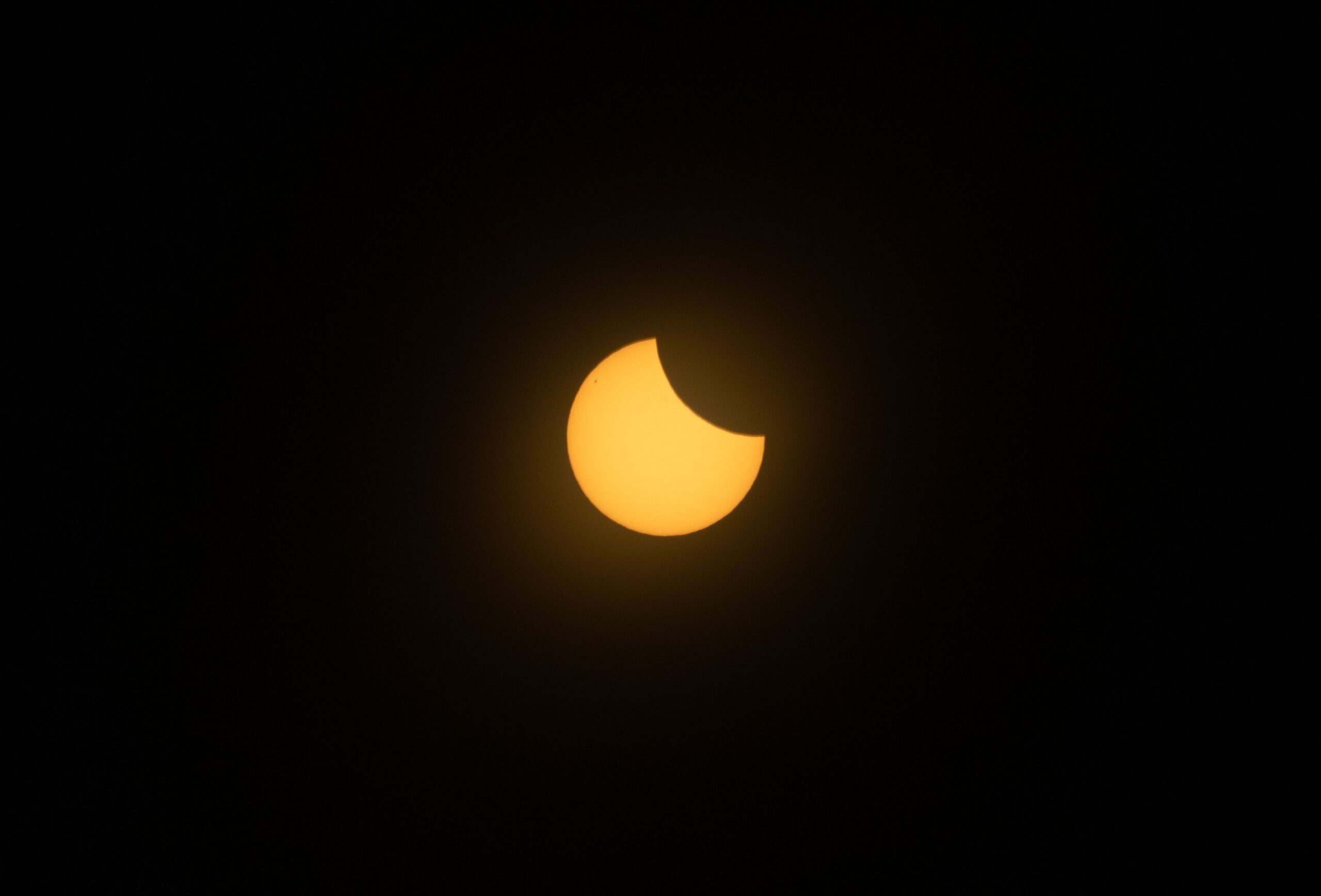 The Sun appears as a glowing crescent during a partial phase of a solar eclipse.