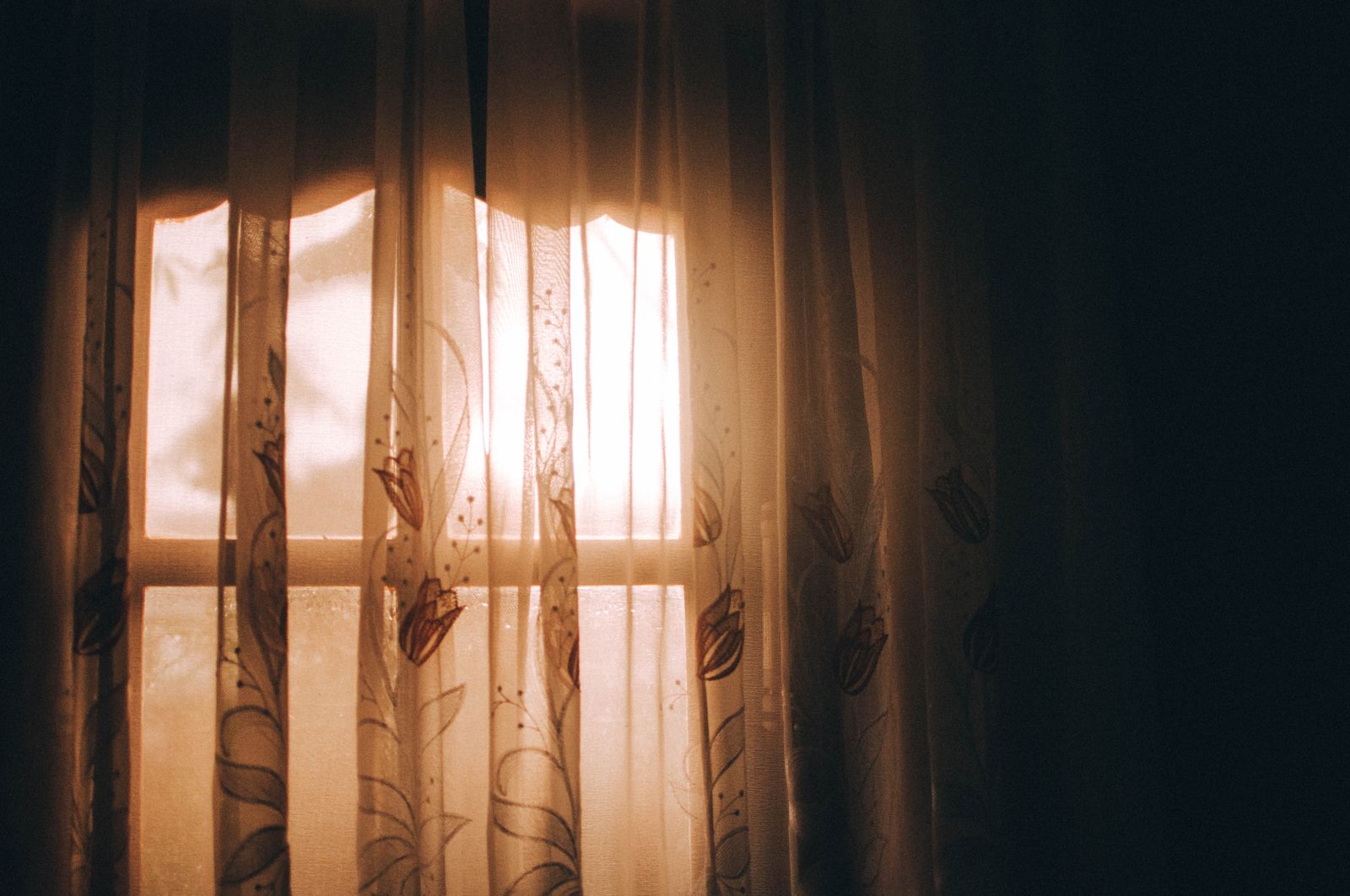 Warm sunlight filtered through curtains inside a room