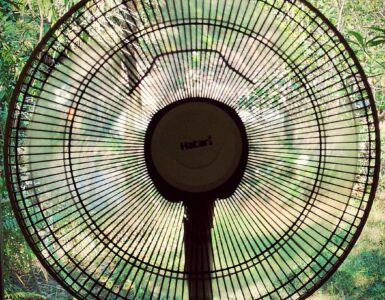 An electric fan with circular grille blades used to move indoor air