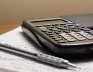 Handwritten math notes and a calculator used to compare factorials, combinations, and binomial coefficients.