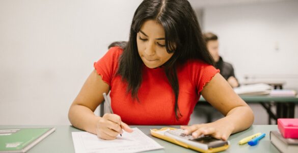 A student uses a calculator while reviewing course scores and class averages.