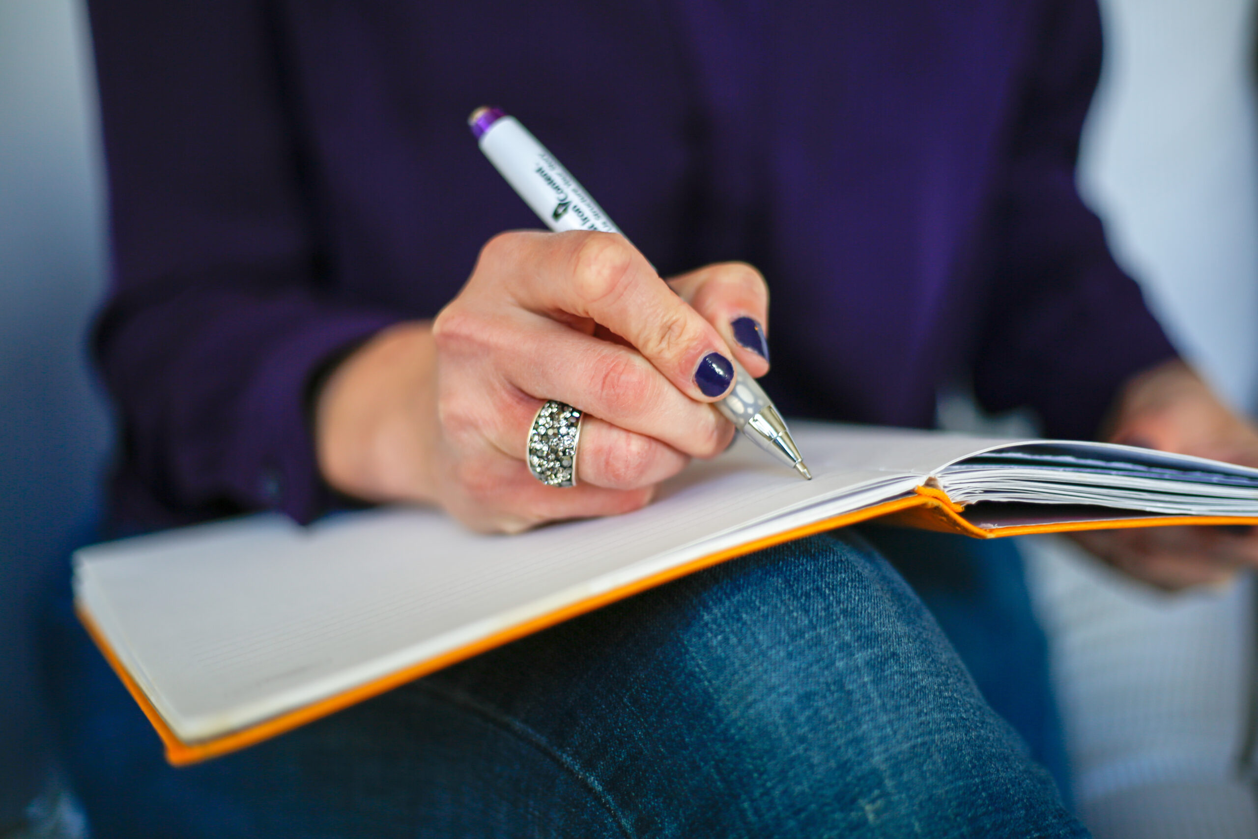 A student writes review questions beside notes while preparing a specific study plan.