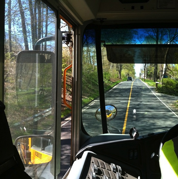 View from inside a school bus showing mirrors and the road ahead