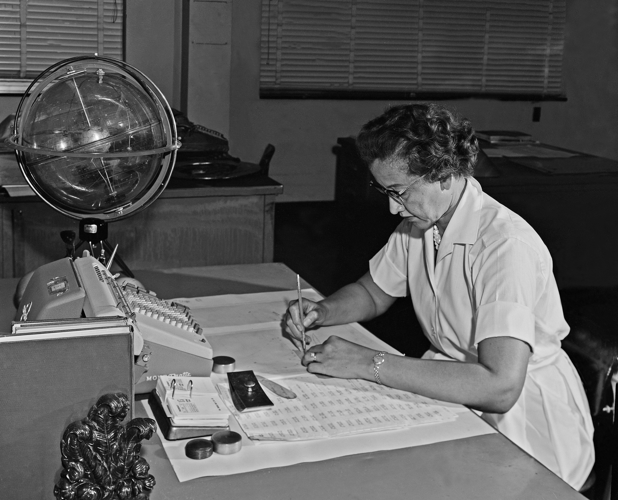 Katherine Johnson working with calculations and a globe at NASA Langley in 1962
