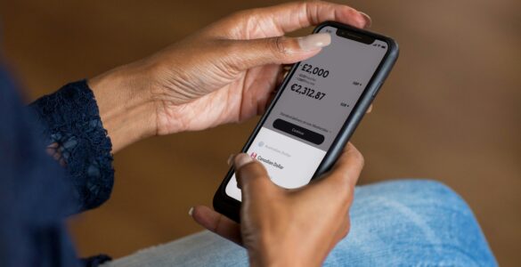 A person checking a mobile banking app, representing account balances and overdraft risk